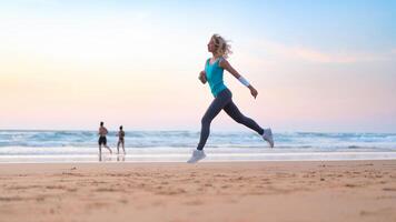 actif sportif femme courir le long de océan le surf par l'eau bassin à garder en forme et santé. le coucher du soleil le sable plage Contexte avec Soleil. femme aptitude, le jogging faire des exercices et sport activité photo