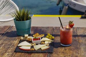 assiette avec assortiment de fromage et fraise Mojito sur le en bois table photo