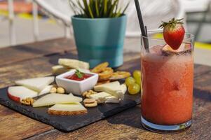 assiette avec assortiment de fromage et fraise Mojito sur le en bois table photo