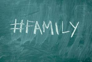 famille hashtag il manuscrit avec blanc craie sur une vert tableau noir photo