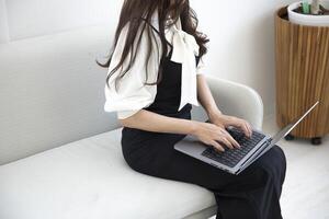 une Japonais femme dactylographie portable par éloigné travail dans le Bureau sans visage composition photo