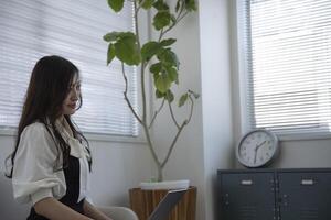 une travail Japonais femme par éloigné travail dans le Accueil Bureau fermer photo