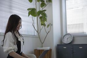 une travail Japonais femme par éloigné travail dans le Accueil Bureau fermer photo