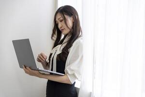 une travail Japonais femme par éloigné travail dans le Accueil Bureau fermer photo