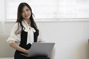 une travail Japonais femme par éloigné travail dans le Accueil Bureau fermer photo