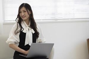 une travail Japonais femme par éloigné travail dans le Accueil Bureau fermer photo