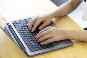 une Japonais femme dactylographie portable par éloigné travail dans le Bureau sans visage composition photo