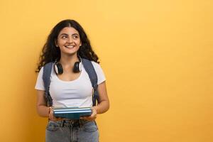 studieux femme en portant livres et à la recherche en haut photo