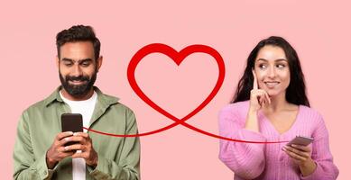 une homme avec une barbe dans une vert chemise les types sur le sien téléphone et une réfléchi femme dans une rose chandail détient la sienne photo