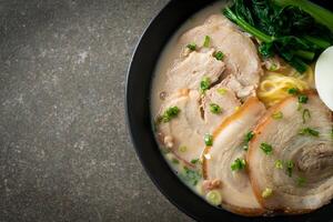 nouilles ramen dans une soupe d'os de porc avec du porc rôti et des œufs photo