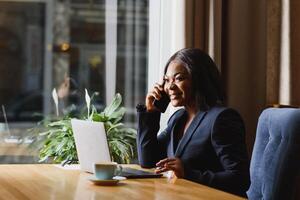 Jeune noir femme d'affaires parlant sur le téléphone. photo