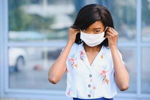 jeune femme bénévole afro-américaine portant un masque facial à l'extérieur. quarantaine de coronavirus et pandémie mondiale. photo