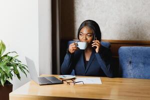 pensif noir femme d'affaires en utilisant tablette ordinateur dans café magasin photo