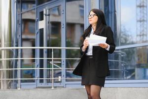 fille avec les documents à une affaires réunion près une moderne bâtiment photo