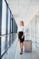 attrayant Jeune femme avec Voyage valise permanent sur seconde sol de aéroport attendre pièce Stock photo