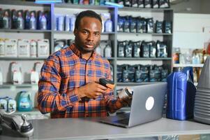 auto les pièces magasin. le vendeur reçoit le produit et évalue le qualité photo