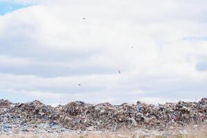 énorme pile de des ordures dans une ville déverser sur sombre journée. en gardant le environnement faire le ménage. écologique problèmes. photo