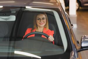 jolie Jeune femme conduite sa Nouveau voiture photo