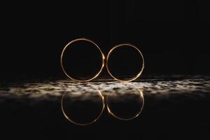 magnifique mariage d'or anneaux sur foncé Contexte photo