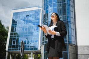 fille avec les documents à une affaires réunion près une moderne bâtiment photo