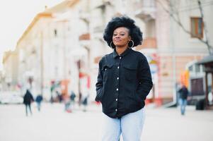 Extérieur proche en haut portrait de Jeune mignonne content souriant africain américain femme avec afro coiffure. photo