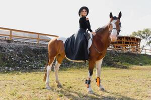 content à la mode Jeune femme posant avec une cheval sur le plage photo