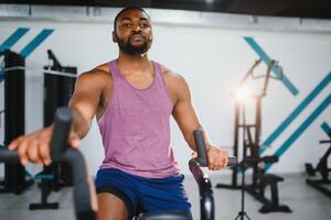 africain homme en utilisant Stationnaire vélo dans une Gym photo