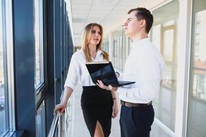 Bureau affaires partenaire spectacle information Les données statistiques en ligne. patron et secrétaire ou assistant travail comme équipe. demander opinion de collègue. homme d'affaire tenir portable surfant l'Internet avec collègue. photo