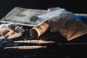 cocaïne et argent isolé sur noir Contexte. photo