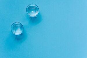 des lunettes de l'eau sur une papier Contexte. dessin ombres. classique bleu couleur. nettoyer l'eau concept photo