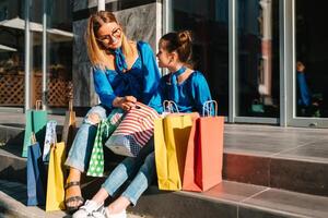 vente, consumérisme et gens concept - content Jeune femmes sa dauther avec achats Sacs en marchant ville rue photo