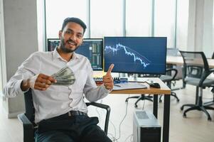 Jeune Indien affaires homme Commerçant à la recherche à ordinateur écran avec commerce graphiques reflétant dans lunettes en train de regarder Stock commerce marché financier Les données croissance concept, proche en haut. photo