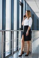 élégant femme d'affaires avec bagage à le aéroport.. attrayant Dame avec Voyage valise en marchant le long de aéroport attendre pièce Stock photo