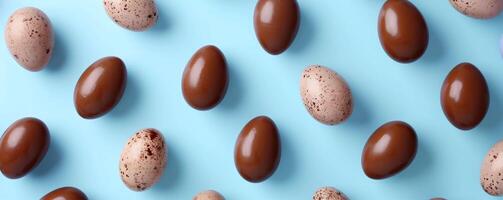 ai généré assorti Chocolat et tacheté des œufs sont arrangé sur une vibrant bleu arrière-plan, formant une modèle. fond d'écran ou Contexte pour Créatif Pâques projets ou culinaire présentations. photo