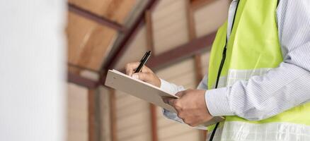 l'inspecteur ou l'ingénieur inspecte la construction et l'assurance qualité de la nouvelle maison à l'aide d'une liste de contrôle. ingénieurs ou architectes ou entrepreneur travaillent pour construire la maison avant de la remettre au propriétaire photo