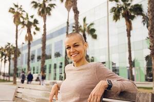 content femme souriant séance dans une parc photo