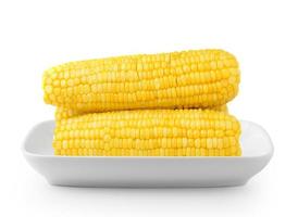 Le maïs sur la plaque blanche isolé sur fond blanc photo