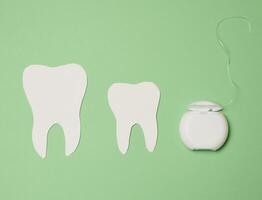 dentaire soie et papier les dents sur vert arrière-plan, oral hygiène photo