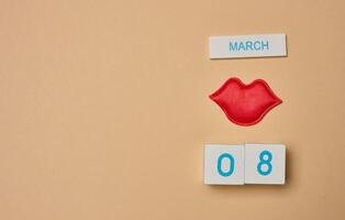 textile rouge lèvres et cubes avec le une inscription Mars 8ème, international aux femmes journée. photo