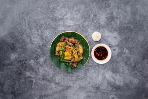 remuer frit poulet cœur et poumons avec poisson sauce servi dans bol isolé sur foncé gris Contexte Haut vue de Japonais nourriture photo