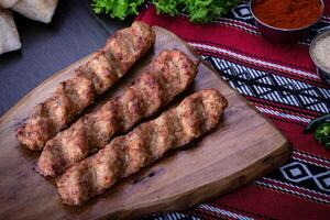 épicé poulet chercher kebab servi dans en bois planche isolé sur table Haut vue de arabe nourriture photo