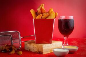 Masala Patate frites isolé sur en bois planche avec mayo tremper et du froid boisson côté vue photo