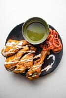 un barbecue poulet tangri ou Tangdi avec le Chili sauce servi dans une plat isolé sur gris Contexte Haut vue de bangladesh nourriture photo