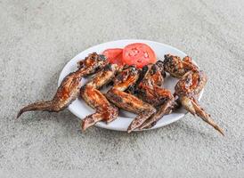 la vitesse poulet Chili ailes avec servi dans une plat isolé sur gris Contexte côté vue de vite nourriture photo
