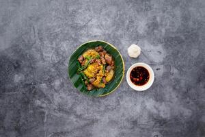 remuer frit poulet cœur et poumons avec poisson sauce servi dans bol isolé sur foncé gris Contexte Haut vue de Japonais nourriture photo