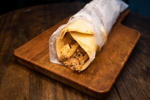 arabe poulet shawarma rouleau emballage servi isolé sur en bois planche Haut vue arabe épicé Fast food photo