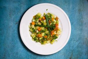 une assiette de spécial mixte vert salade salade avec concombre, tomate, printemps oignon et vert Chili isolé sur Contexte Haut vue de en bonne santé nourriture suivre un régime photo