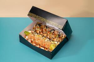 mixte Sushi plat servi dans une boîte isolé sur bleu Contexte côté vue de Japonais vite nourriture photo