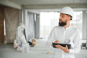 Jeune attrayant arabe industriel ingénieur dans difficile chapeau. professionnel et industrie, constructeur architecte emploi, ouvrier vérification travail à plante intérieur photo