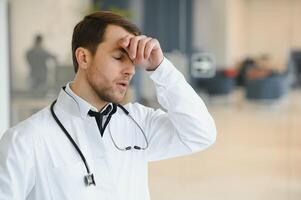 stressé Masculin médecin. milieu adulte Masculin médecin travail longue heures. surmené médecin dans le sien bureau. ne pas même médecins sont exempter de Burnout . photo